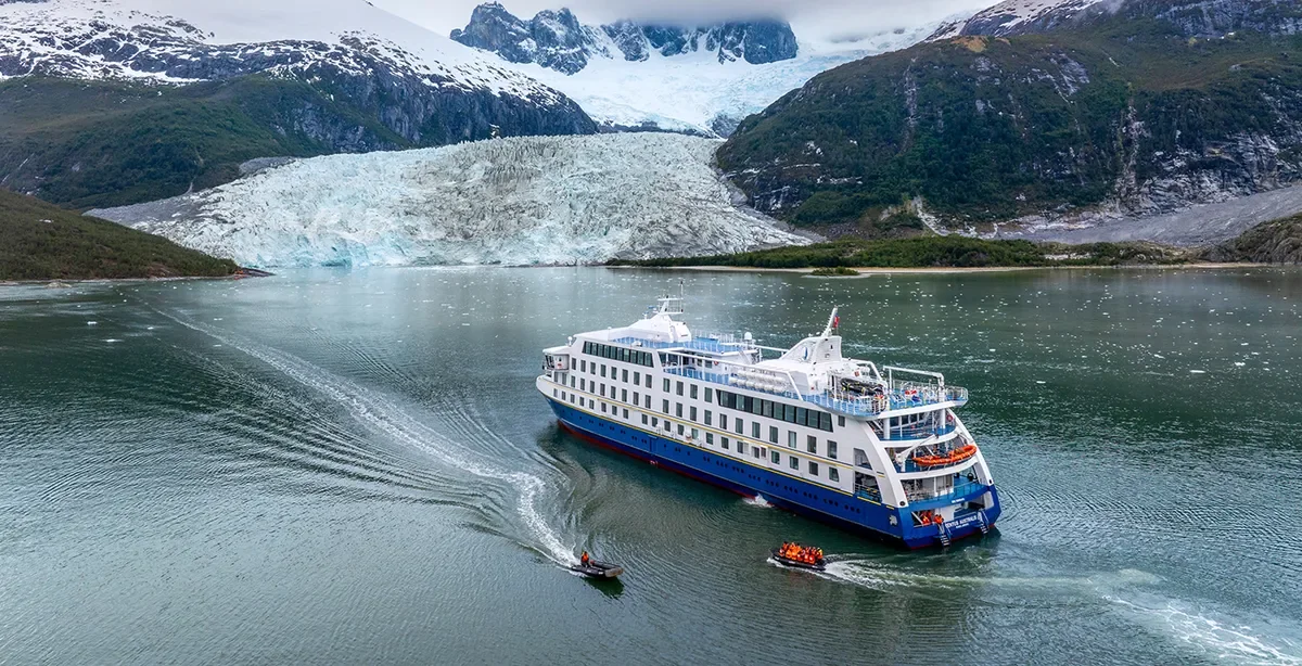 Expedition cruise ship navigating Chilean fjords near a glacier in Patagonia